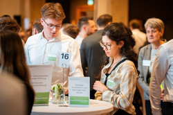 Das Bild zeigt Studierende an einem Stehtisch.