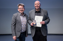 Foto: Markus Alex (ITMC) überreicht Uwe Grützner den  Lehrpreis für lehrunterstützendes Engagement von Mitarbeitenden in Technik und Verwaltung.