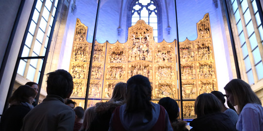 Kinder zu Besuch in der St. Petri Kirche bewundern den goldenen Altar
