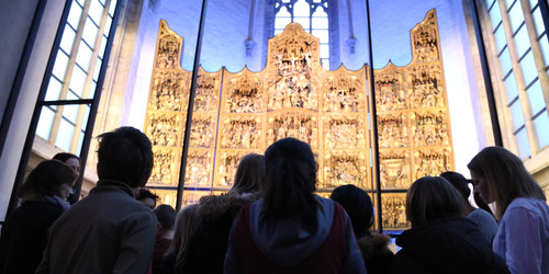 Kinder zu Besuch in der St. Petri Kirche bewundern den goldenen Altar 