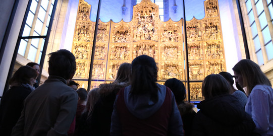 Kinder zu Besuch in der St. Petri Kirche bewundern den goldenen Altar 