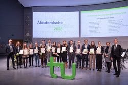 Die Preisträger*innen der Jahrgangsbestenpreise stehen mit ihren Urkunden auf der Bühne des Audimax