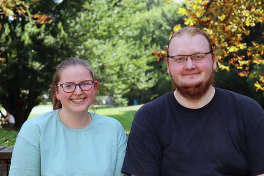 Photo: Annika Ricke and Darius Weitekamp are standing on the campus of TU Dortmund University. Trees can be seen in the background.