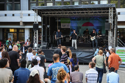 Photo: A band plays on a large stage in front of the EF50 building.