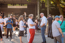 Summer festival 2022 Visitors of a summer festival are gathered outside in front of a stage.