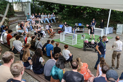 Photo: People sit in the stands in the audience at a soccer robot match.