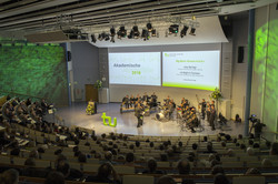 Gesamtansicht Audimax Gesamtansicht Audimax von oben, über die Sitzreihen hin zur Bühne - Der Saal ist in grünes Licht getaucht