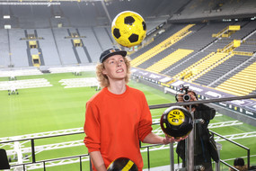 Student jongliert mit BVB Fußbällen