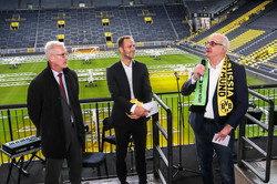 From left: Thomas Treß, Christoph Edeler and Prof. Manfred Bayer (with TU-BVB scarf) stand on a stadium stand. The pitch can be seen in the background.