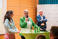 Moderatorin Britt Lorenzen moderiert die Verleihung der Urkunden an die Fördernden, unterstützt von Vera Pleßer (Referat Hochschulmarketing)