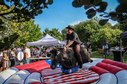 Photo: A man in a cowboy hat rides a mechanical bull.