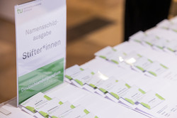 Namensschilder für die Fördernden liegen ordentlich aufgereiht auf einem Tisch, um dort abgeholt werden zu können