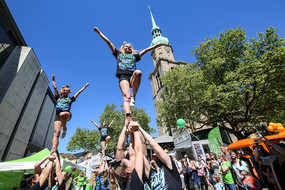 TU Dortmund cheerleaders pile into the air in front of Reinoldi Church