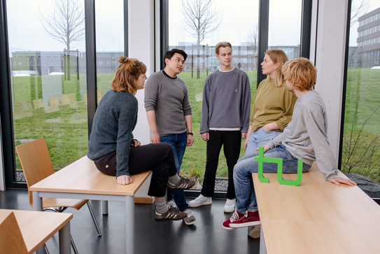 Ein Gruppenfoto von Studierenden im Seminarraum mit dem TU Dortmund Logo.